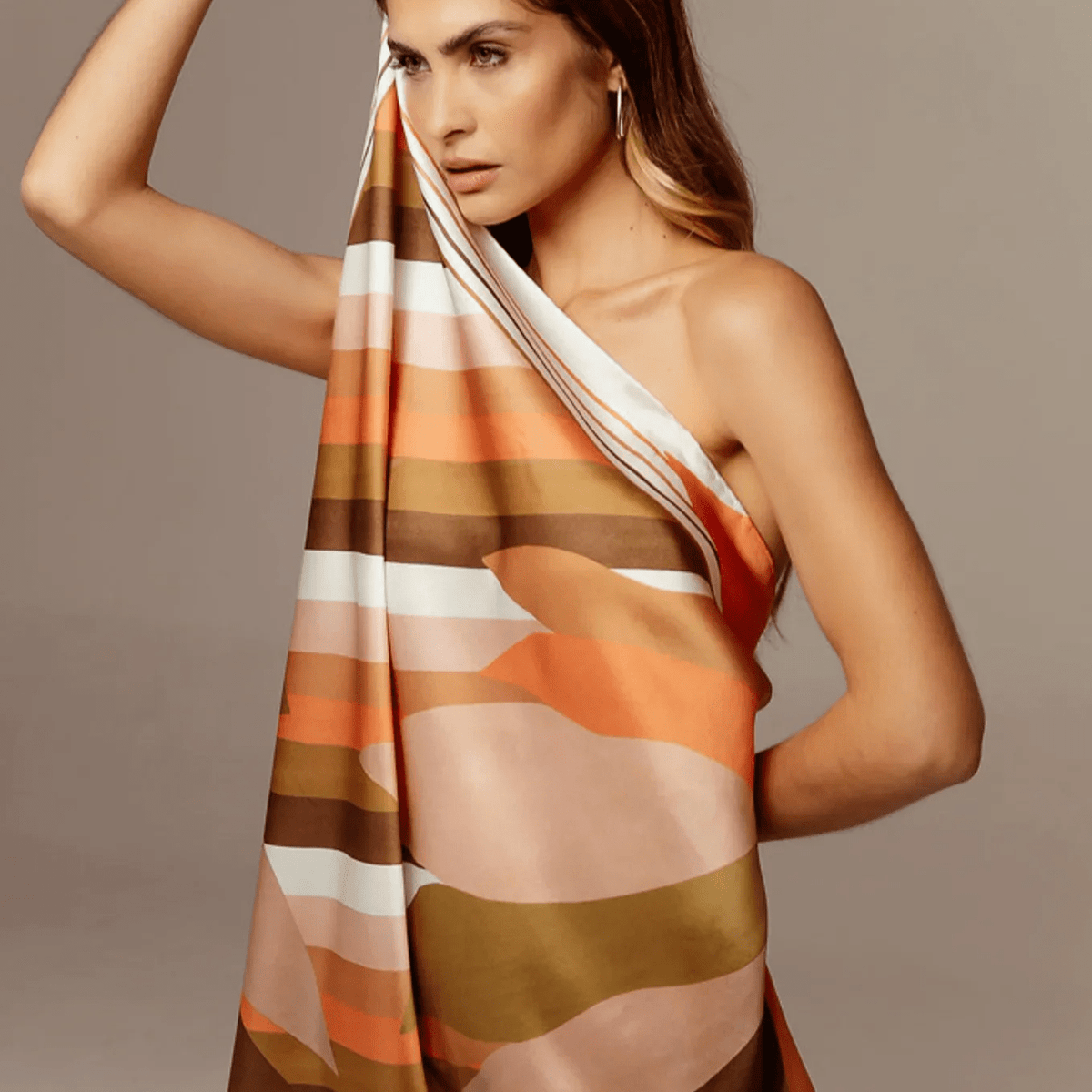 Woman wearing a colorful, abstract-patterned sustainable silk dress