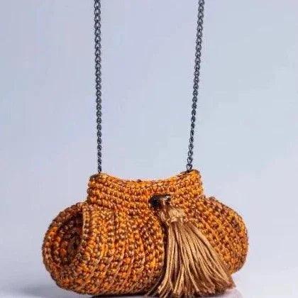 Handcrafted crochet handbag with chain strap and tassel in orange tones