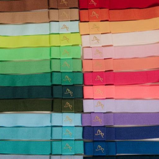 Colorful hat bands arranged in rows, showcasing a variety of vibrant fabric shades.