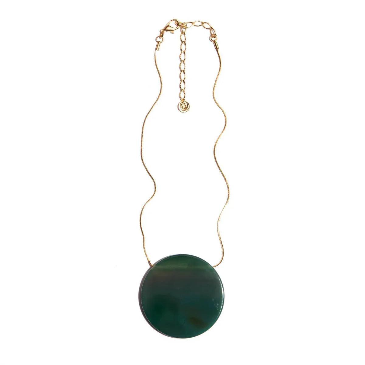 Gold chain necklace with large green round stone pendant on white background