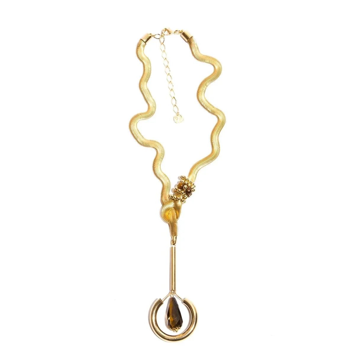 Gold statement necklace with wavy chain and brown teardrop pendant on white background